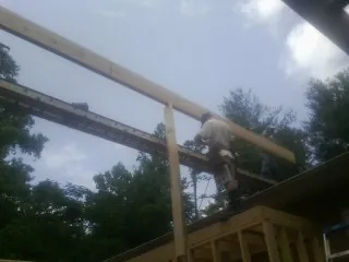 Carpenter setting a ridge beam over a new addition frame — Ice Dam Removal by Roofing Brothers in Callaway